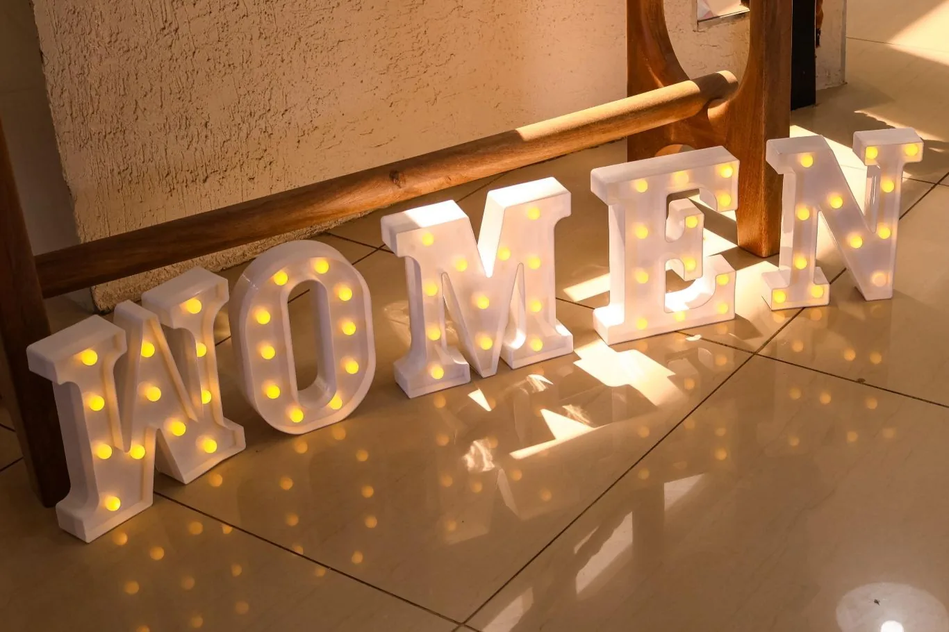 Illuminated WOMEN marquee letters at a Women's Day celebration